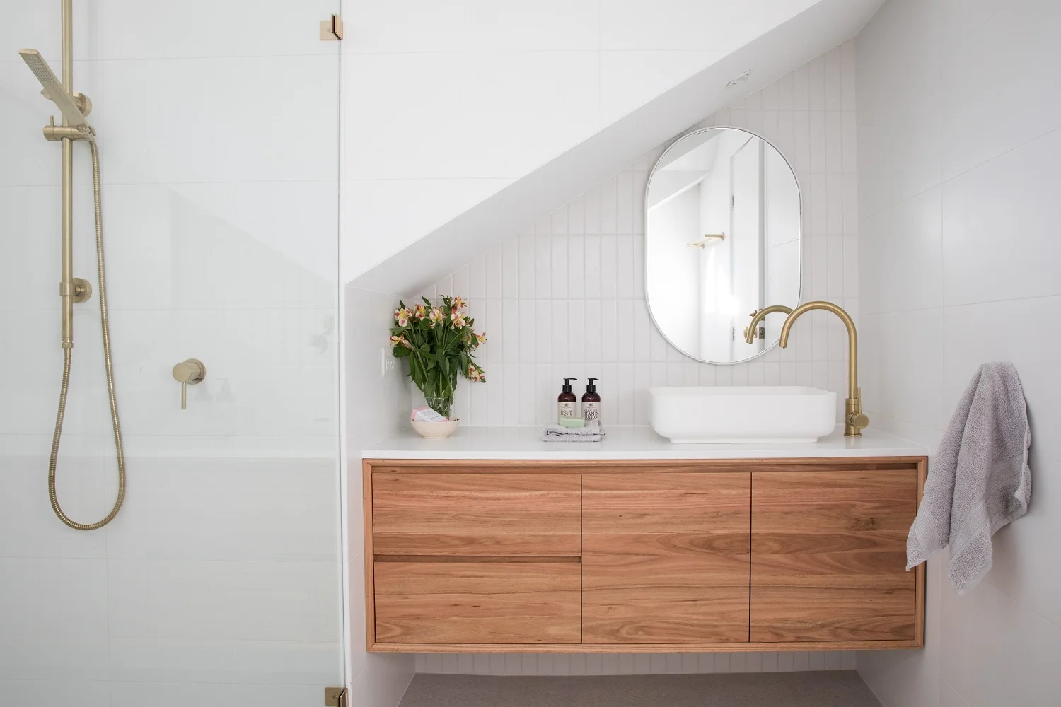white bathroom with wooden cabinets