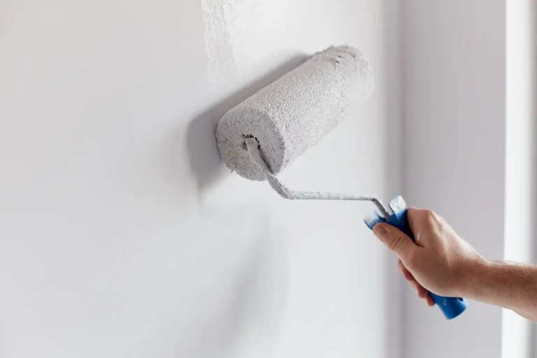 painter paints a wall with a roller