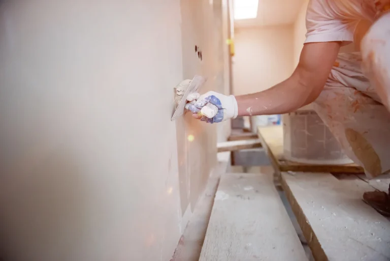 construction worker applies smoothness to a wall