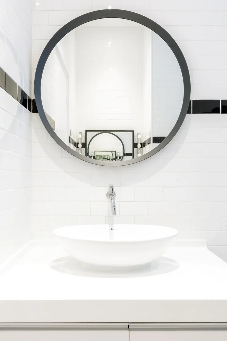 mirror and washbasin in white cosy bathroom after renovation